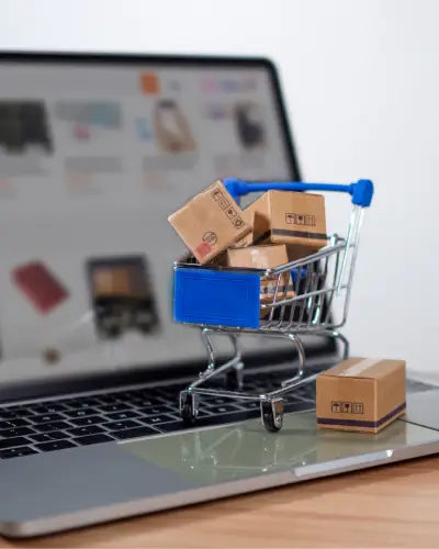 Miniature shopping cart with parcels on a laptop keyboard